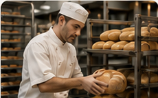 Bakery professional handling fresh bread in a commercial bakery